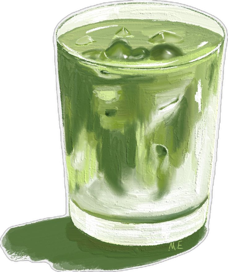 a glass filled with green liquid sitting on top of a table