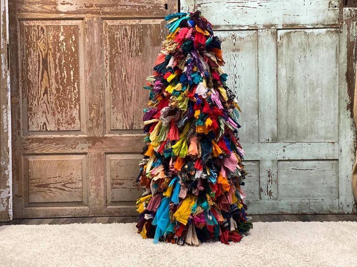 a multicolored dress made out of old clothes hanging in front of a door