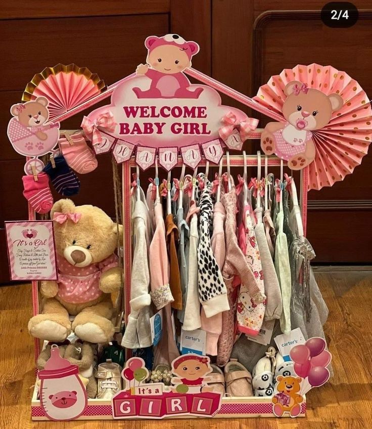 a welcome baby girl display with teddy bears and other items in the background on a wooden floor