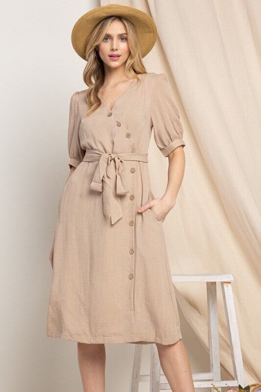 Elevate your wardrobe with our Asymmetrical Button-Down Wrapped Midi Dress, a true embodiment of timeless elegance and style. This dress offers a perfect blend of sophistication and modern flair, ensuring you'll look effortlessly chic and feel confident on any occasion. Key Features: Half-Sleeve Design: The dress features a half-sleeve with button closure, providing a touch of modesty and versatility. You can adjust the sleeves to your preference, making it suitable for various weather condition Cheap Brown Dress With Button Closure, Elegant Dresses With Button Closure, Classic V-neck Midi Dress With Buttons, Spring Elegant Midi Dress With Buttons, Elegant Spring Midi Dress With Buttons, Spring Midi Dress With Asymmetrical Hem And Belt, Elegant Beige Button-up Dress, Elegant Beige Midi Dress With Button Closure, Elegant Knee-length Midi Dress With Covered Buttons