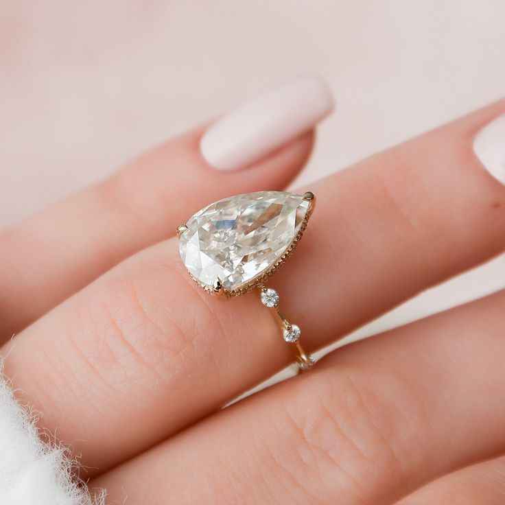 a woman's hand with a ring on it and a diamond in the middle