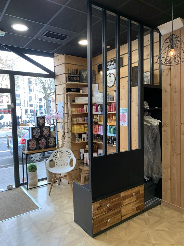 the inside of a store with lots of shelves and chairs in front of it's glass doors