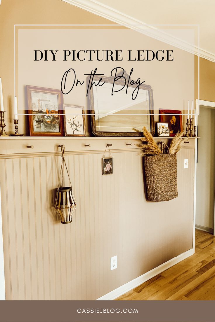 a room with pictures on the wall and a basket hanging from the fireplace mantel