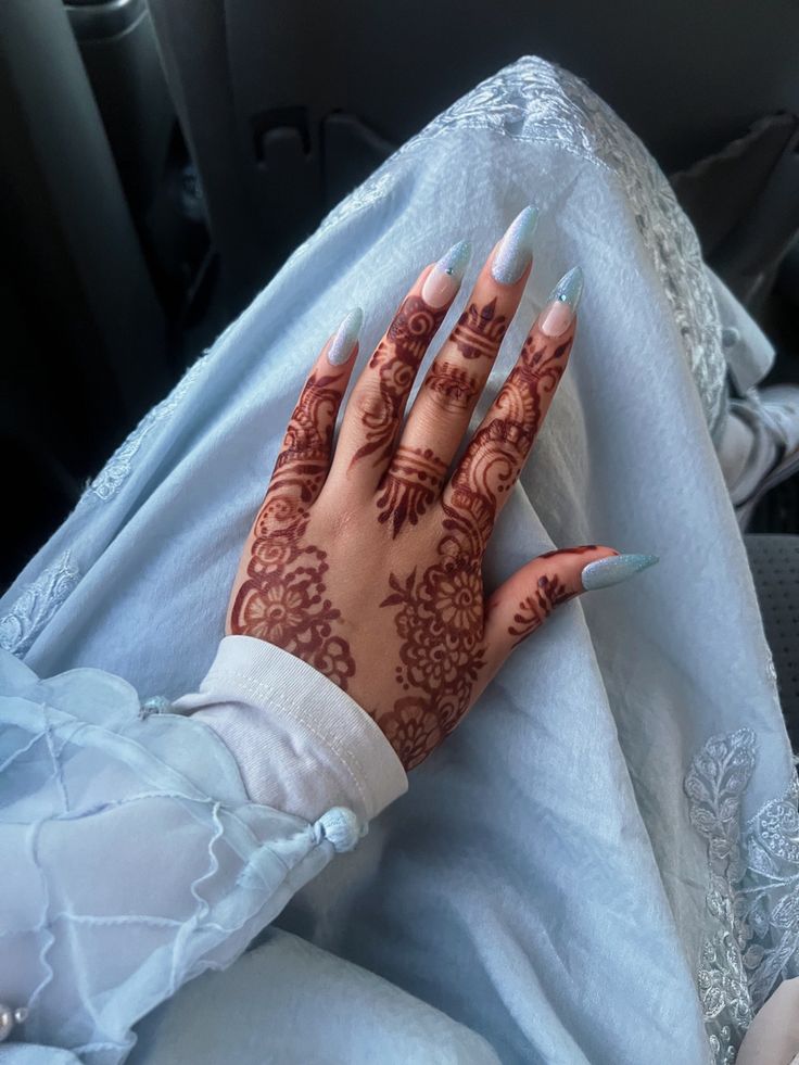 a woman's hand with henna on it sitting in the back seat of a car