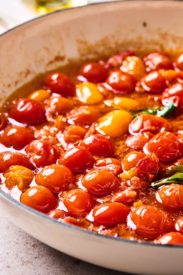 a pan filled with lots of tomatoes on top of a table