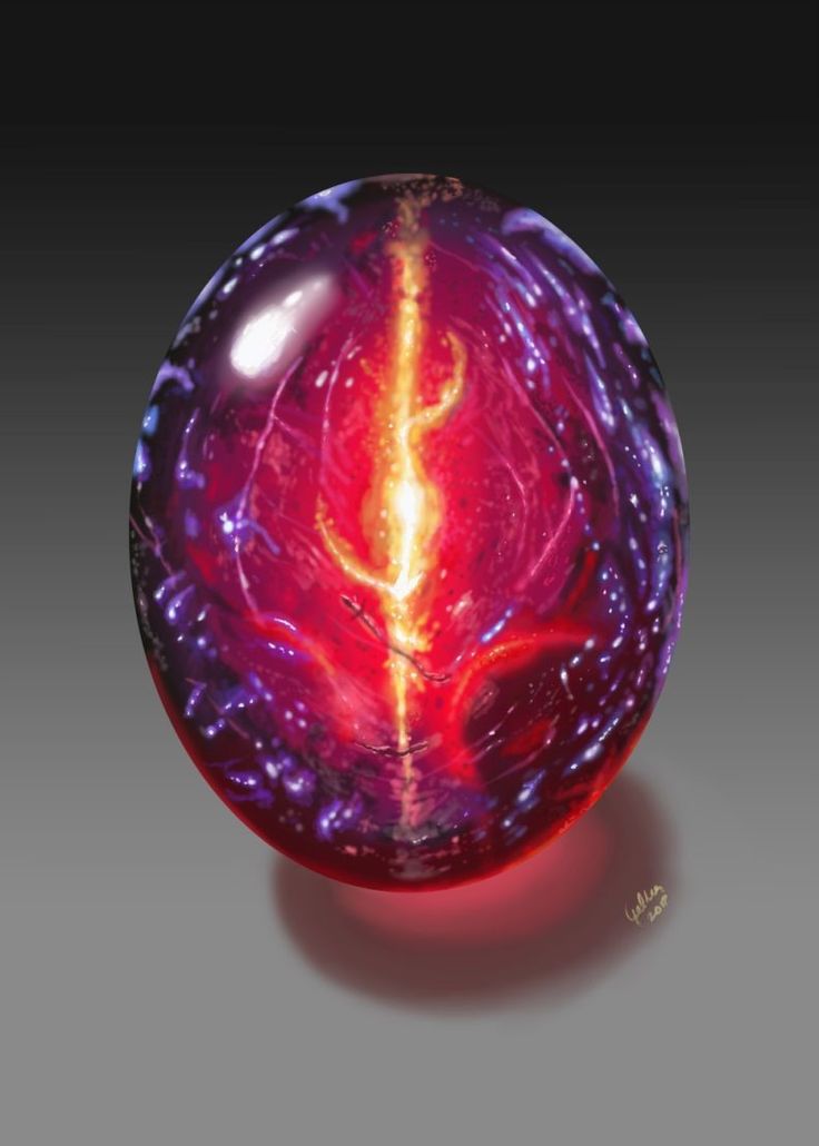 a red and purple glass object on a gray surface with an orange light in the center