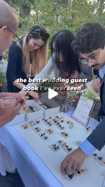 a group of people standing around a table with cards and magnets on it that says, the best wedding guest book i've ever seen