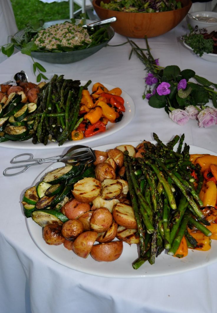 two plates filled with different types of vegetables on a white table cloth covered tablecloth