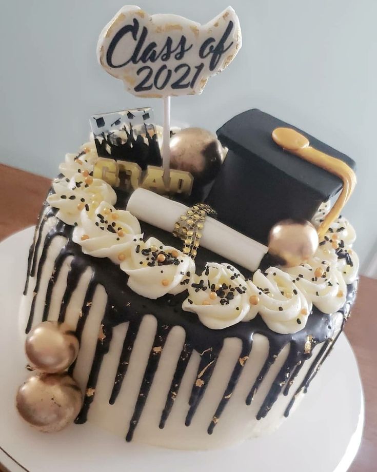 a graduation cake decorated with white frosting and black icing