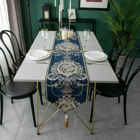 the table runner is decorated with gold, blue and white floral designs on it's edge