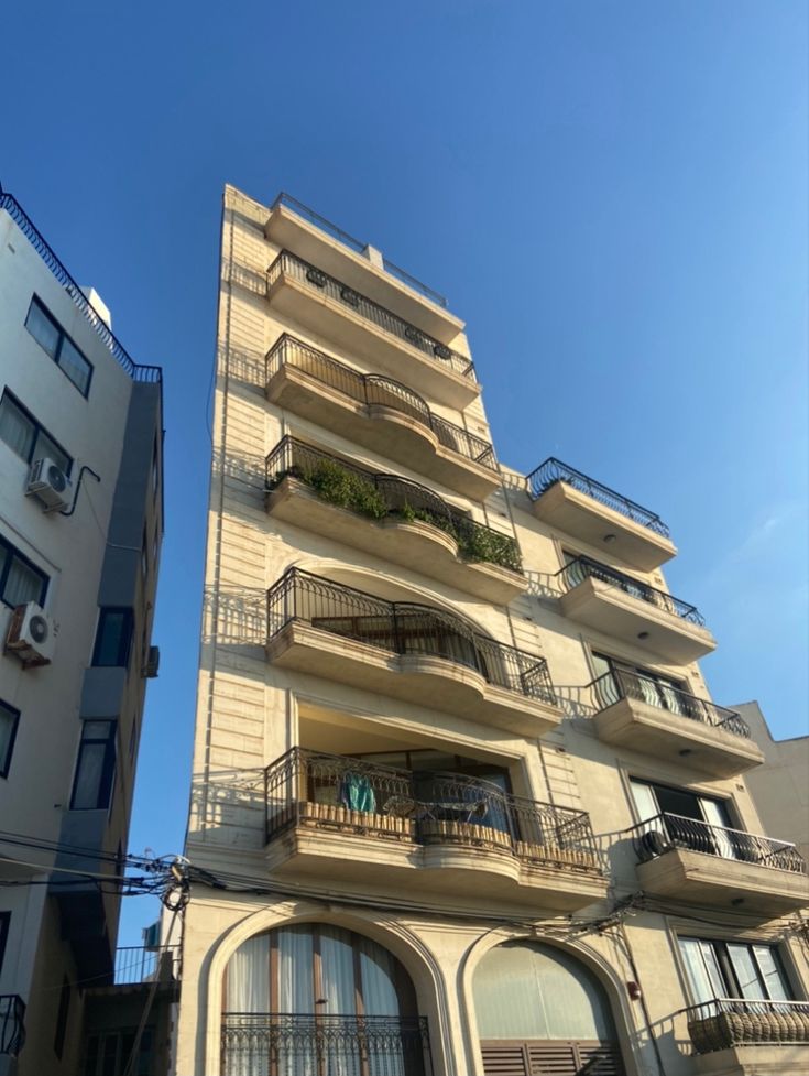 an apartment building with balconies and plants on the balconies above it