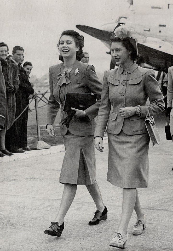 two women walking next to each other in front of an airplane