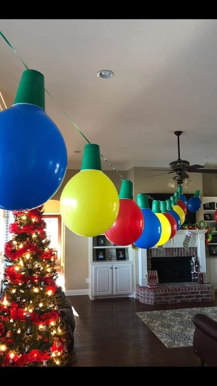 a christmas tree is decorated with balloons and lights