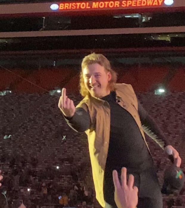 a man standing on top of a stage with his hands in the air