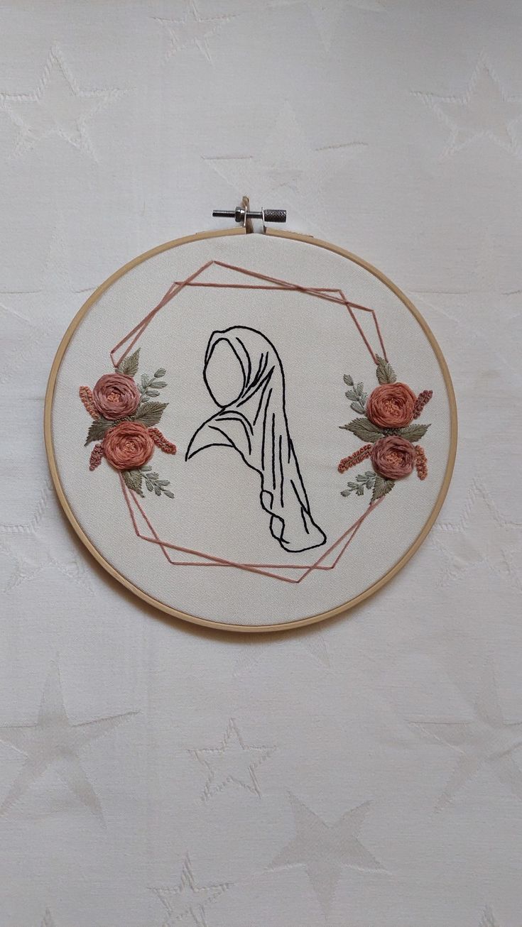 a cross stitched picture with roses on it and a woman's face in the middle