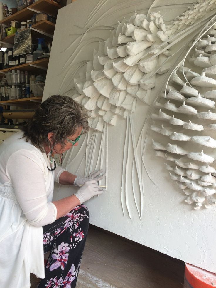 a woman is working on an art piece