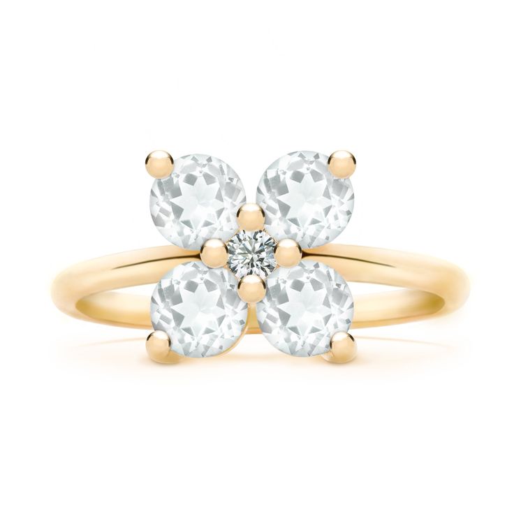 a yellow gold ring with two white stones on the top and one diamond in the middle