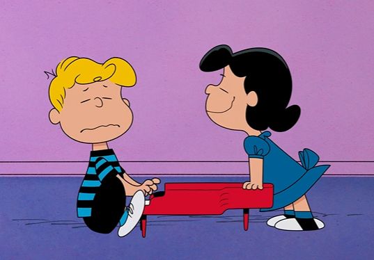 a cartoon character sitting on top of a red bench next to a person wearing a blue and white striped shirt