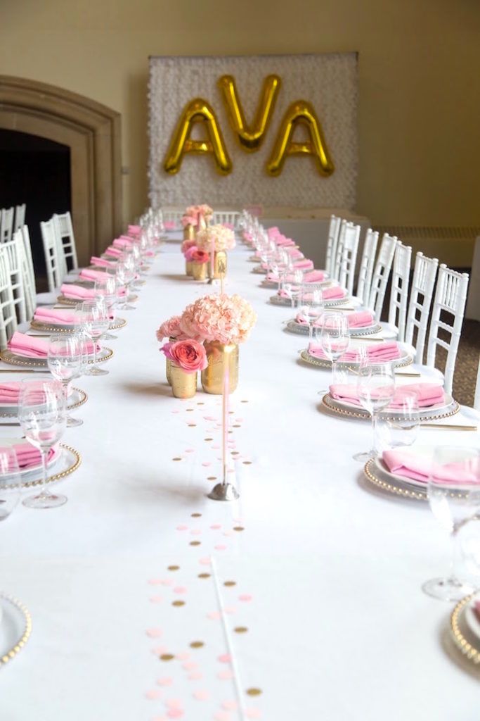 a long table is set with pink and gold place settings for an elegant wedding reception