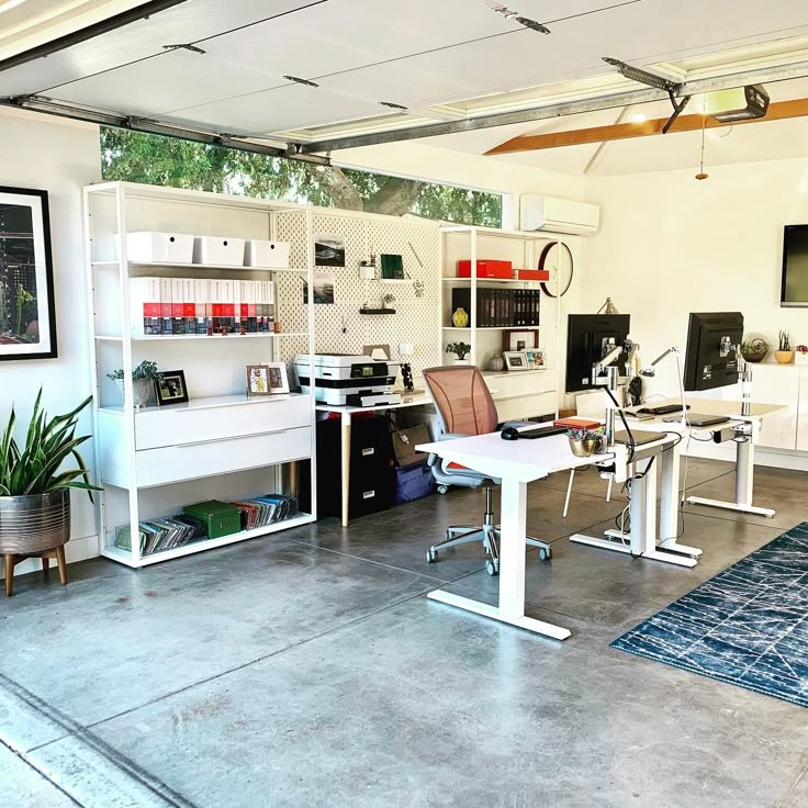 a home office with two desks and shelves on the wall, along with a rug