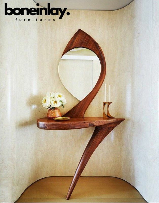 a wooden table with a mirror and vase on it