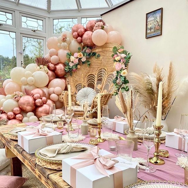 a table set up for a party with pink and gold decorations