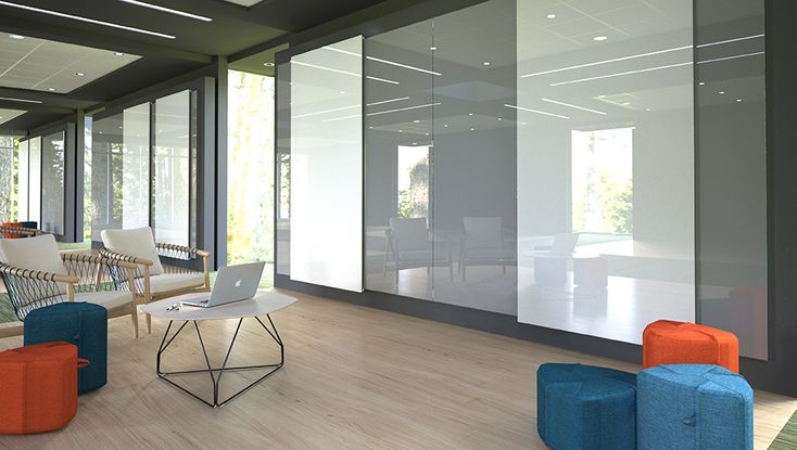 a living room filled with lots of furniture next to tall glass windows on the wall