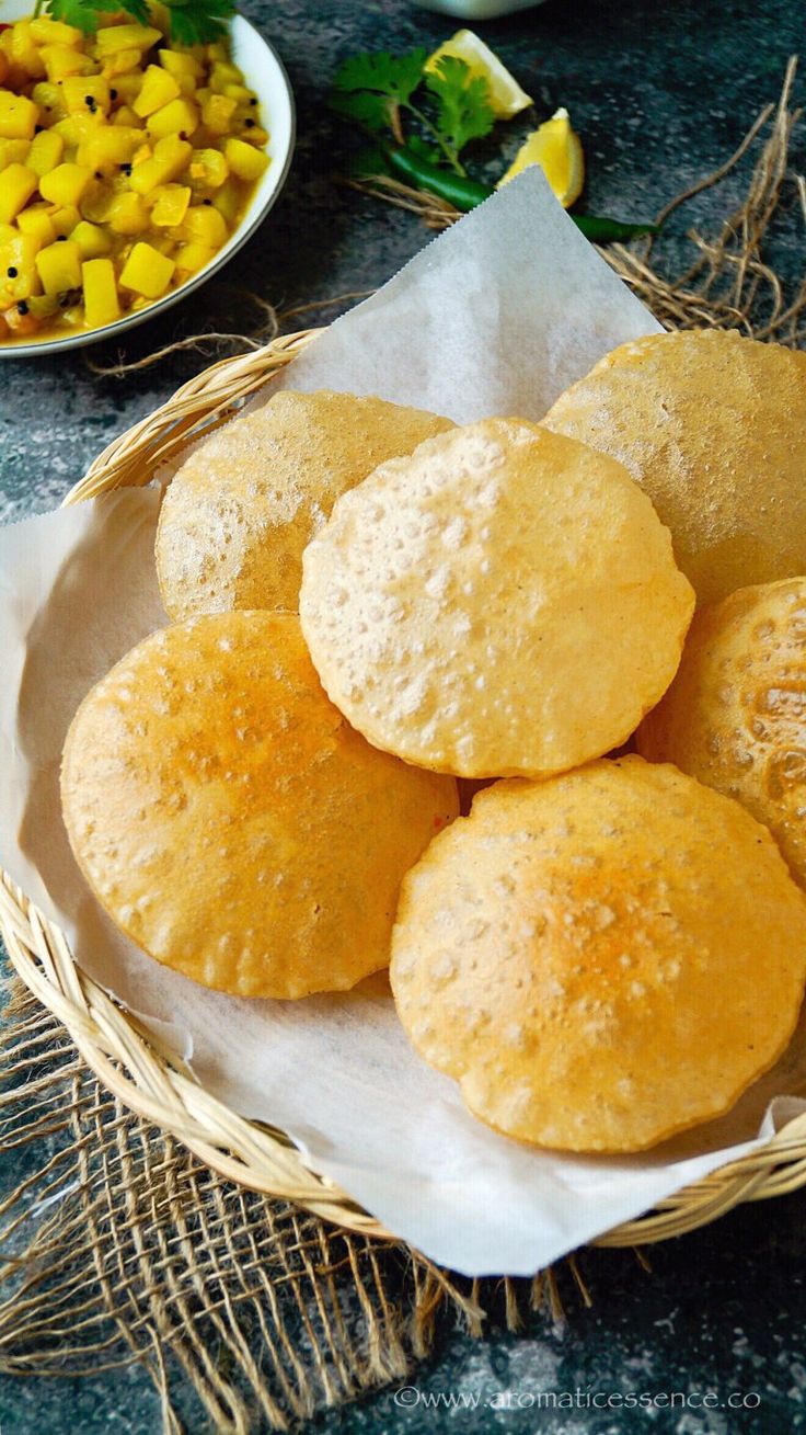 some food is sitting in a basket on the table next to other plates and bowls