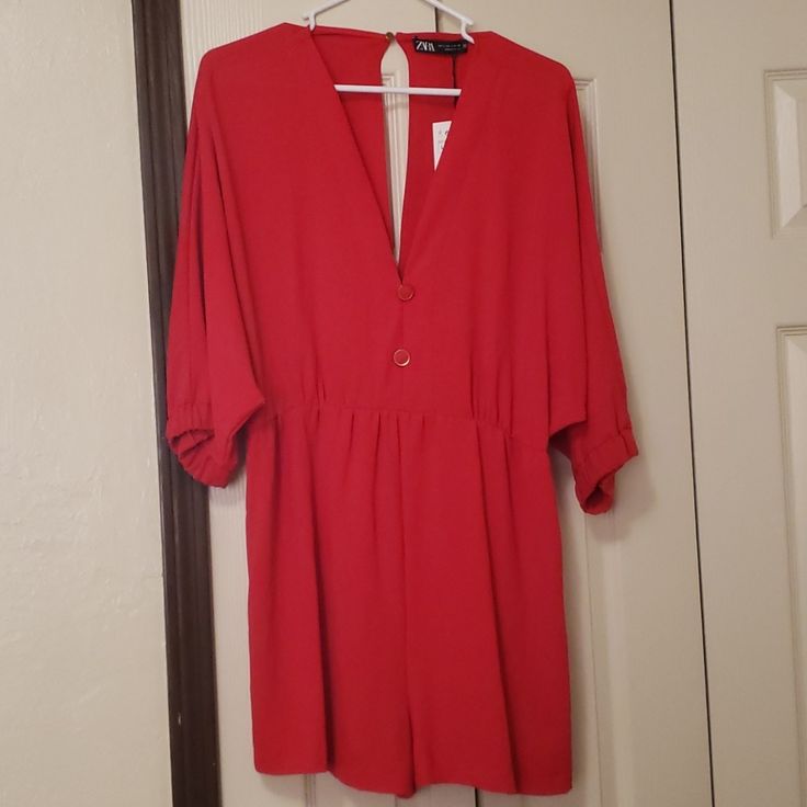 Has 2 Non Functional Red And Gold Buttons, One Button Closure In Back, Batwing Sleeves Elastic At End Of Sleeves, Sleeves Fall Under Elbow, Elastic At Waist Waist 15.5 In Total Length 31 In Sleeve To Sleeve 42in Waist To Hem 15.5 In Chic V-neck Jumpsuits And Rompers With Button Closure, Chic V-neck Jumpsuits And Rompers With Buttons, Red Solid Color Jumpsuits And Rompers For Night Out, Red Solid Color Jumpsuit For Night Out, Red V-neck Jumpsuit And Romper, Red Solid Color Jumpsuits And Rompers For Spring, Solid V-neck Jumpsuits And Rompers With Buttons, Solid V-neck Jumpsuit With Buttons, Spring V-neck Jumpsuits And Rompers