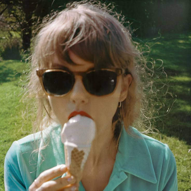 a woman in sunglasses eating an ice cream cone