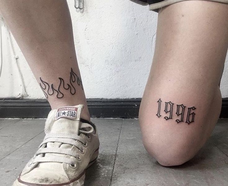 two people with tattoos on their legs and one has a name tattooed on the lower leg