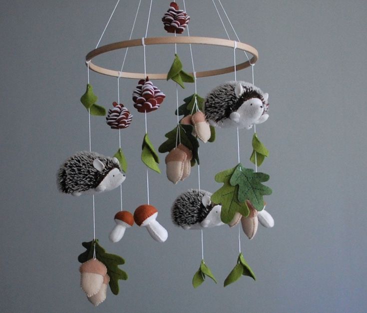 a mobile made out of felt with hedges and pine cones hanging from it