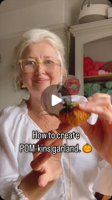 a woman is holding something in her hand with the caption how to create pom - kins garland