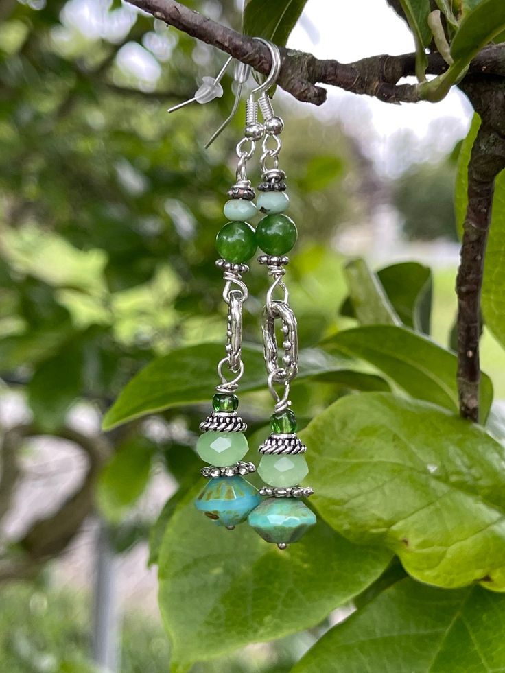 Czech green colored glass beads. Sterling silver and mixed metals. 2 inches in length Green Crystal Metal Earrings, Green Dangling Bead Chandelier Earrings, Elegant Jade Beaded Earrings, Handmade Bohemian Green Crystal Earrings, Bohemian Green Handmade Crystal Earrings, Adjustable Green Beaded Chandelier Earrings, Handmade Green Crystal Metal Earrings, Green Czech Glass Jewelry With Dangling Beads, Adjustable Green Chandelier Earrings With Dangling Beads