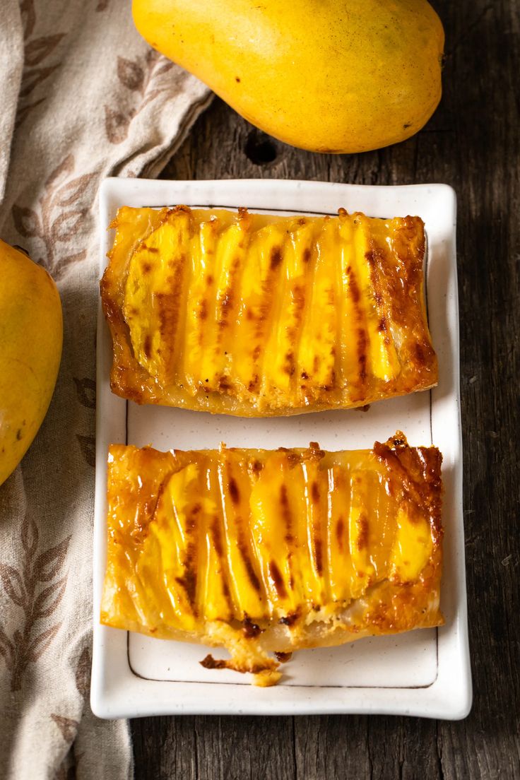 two slices of banana bread on a white plate next to some pears and a yellow squash