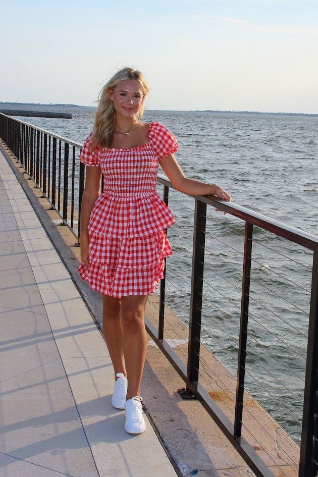 Lizzy is our newest LOVE! Look at this dress, it screams all things Summer, and Americana! Unleash your summer adventures in this trendy and playful MINI DRESS! With a charming SQUARE NECK and flattering SMOCKED BODICE, this dress will have you looking effortlessly stylish. The TIERED design adds a fun and unique touch to this red and white gingham dress. Model is 5'7 wearing small- runs true to size The red gingham • Fabric: - SELF: 97% POLYESTER 3% SPANDEX - LINING : 100% POLYESTER Casual Summer Mini Dress For Picnic, Flirty Summer Mini Dress For Picnic, Flirty Mini Dress For Summer Picnic, Flirty Mini Dress For Picnic, Cute Summer Mini Dress With Square Neck, Cute Square Neck Mini Dress For Summer, Cute Square Neck Summer Mini Dress, Summer Gingham Mini Dress With Short Sleeves, Summer Mini Dress For Picnic With Short Sleeves