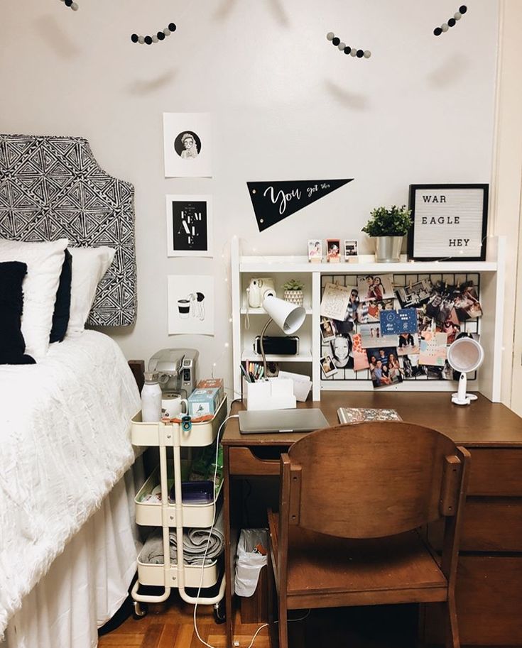 a bed room with a neatly made bed next to a wooden desk and chair on top of it