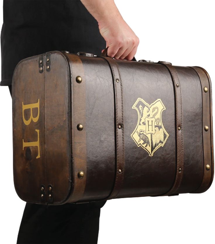 a man carrying a brown leather suitcase with hogwart's crest on the side