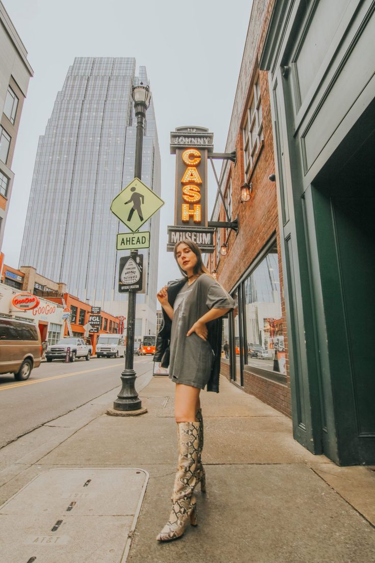 a woman is standing on the sidewalk in front of a sign that says, chicago