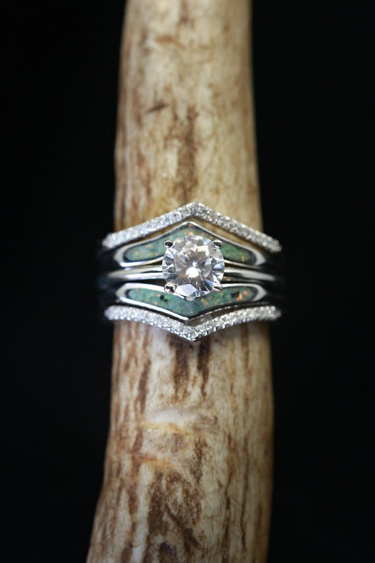 a diamond ring sitting on top of a piece of wood