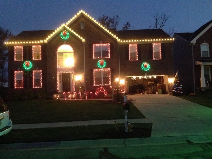 a house is decorated with christmas lights and wreaths