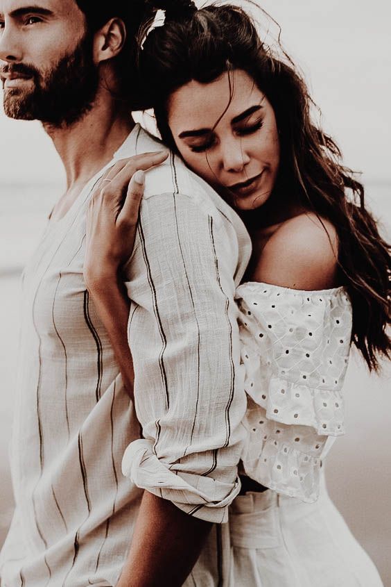 a man and woman embracing each other on the beach