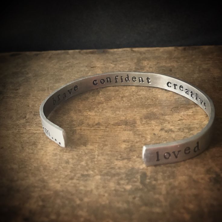 "This custom bracelet is hand stamped with your personalized wording. It is a skinnier version of my popular \"I am...loved\" bracelet. This little beauty is approximately 1/4 inch wide. Remind yourself (or someone special) how great you really are. This bracelet is stamped with a discreet \"I am...\" on the bottom of one side, and \"loved\" on the other. The inside of the cuff holds up to 5 words of your choice of words. Customize it your way! The outside of the bracelet has a gently textured f Personalized Meaningful Name Bracelet, Adjustable Everyday Jewelry With Custom Text, Adjustable Custom Text Jewelry For Everyday Wear, Meaningful Personalized Bangle Bracelet, Adjustable Customizable Meaningful Bracelet, Customizable Meaningful Bracelets For Everyday, Inspirational Adjustable Customizable Bracelets, Inspirational Customizable Adjustable Bracelets, Meaningful Hypoallergenic Bracelet For Best Friend Gift