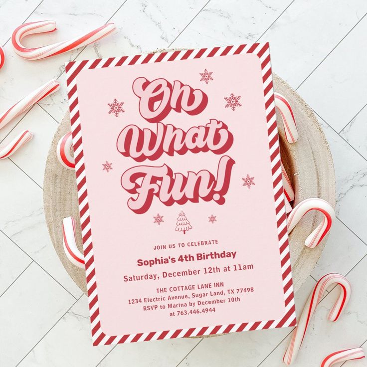 a pink and red birthday party card with candy canes on the table next to it