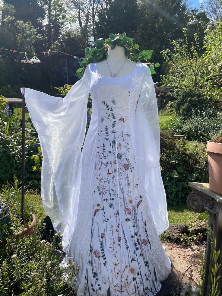 a white dress on display in a garden