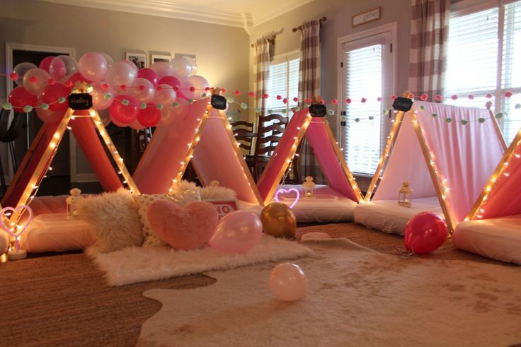 some balloons and lights are on the floor in front of a room with pink curtains