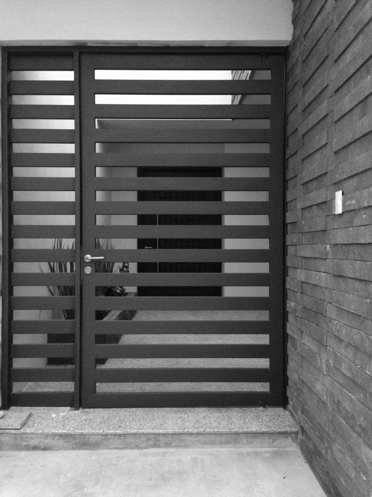 a black and white photo of a modern gate