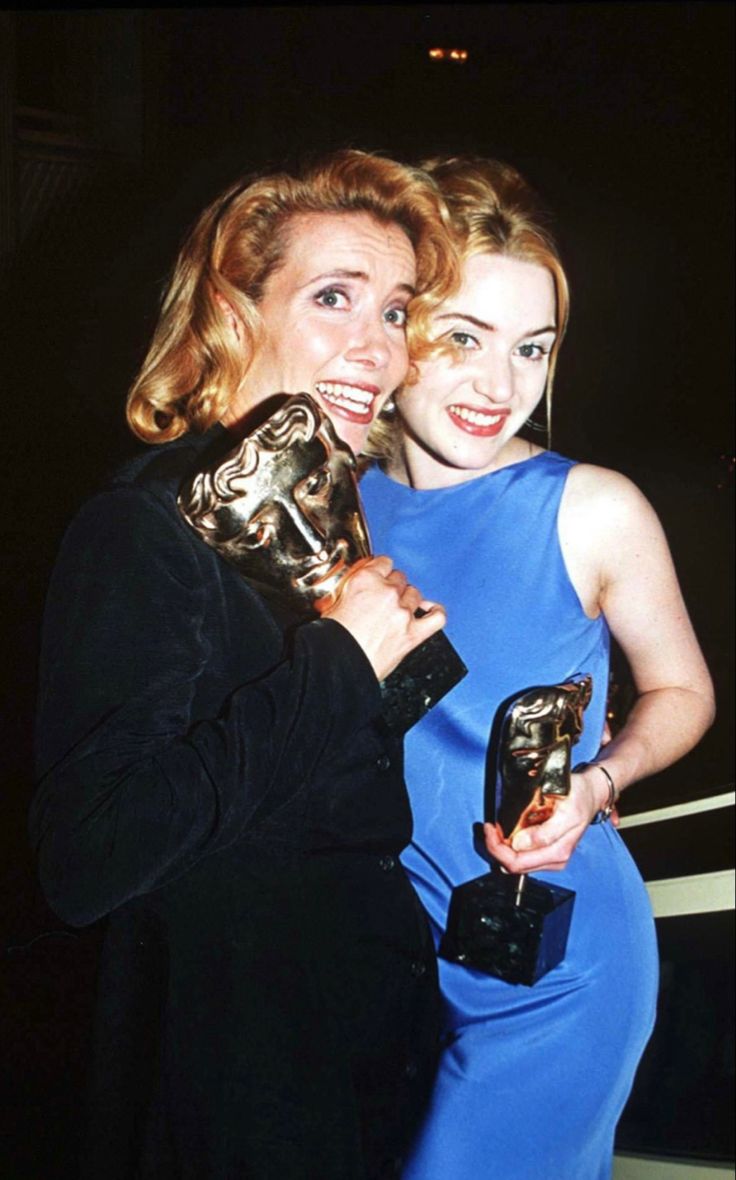 two women standing next to each other holding their oscars trophies in front of them