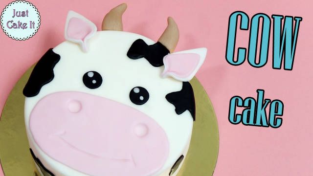 there is a cake decorated like a cow on the plate and it says cow cake