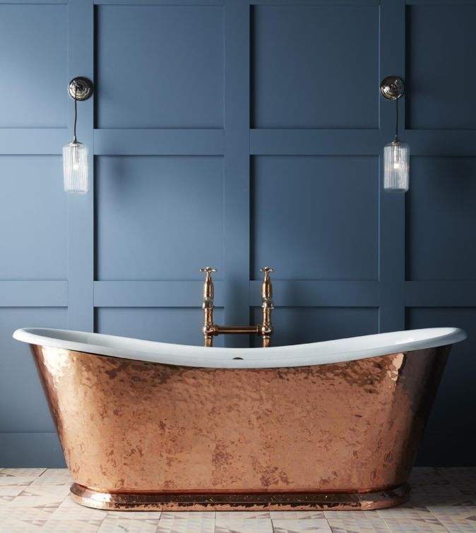 an old fashioned bathtub in a bathroom with blue walls